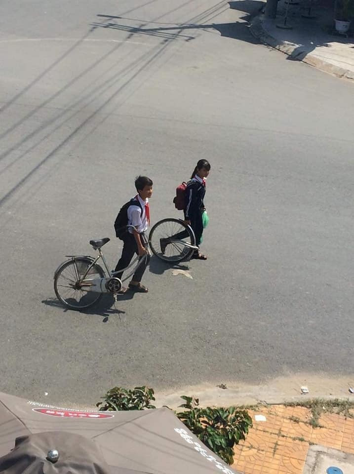 Hai cô cậu học trò, cổ còn đeo khăn quàng đỏ cùng nhau trở về sau giờ tan học.