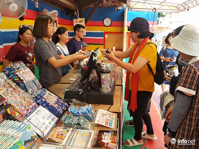 Du khách mua hàng lưu niệm của Làng Cầu Vồng...