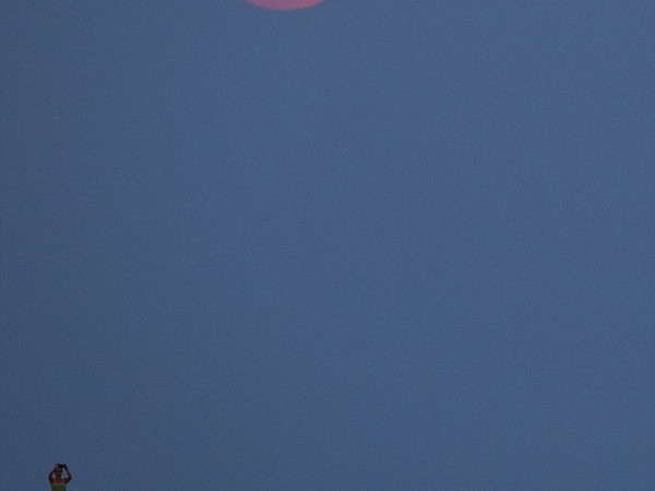 Một phụ nữ đang ghi lại cảnh trăng máu xuất hiện ở làng Sivrice, Canakkale, Thổ Nhĩ Kỳ (Ảnh: EPA)