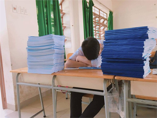 Khi đề cương đã không còn tính bằng trang, mà được tổng hợp thành từng quyển dày, chất cao hơn đầu. (Ảnh: Đậu Văn Nhật Hoàng)