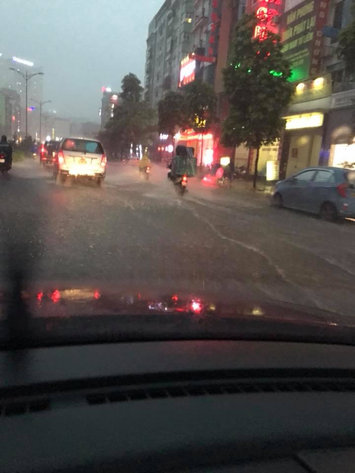 Khu vực đường Vũ Phạm Hàm, mưa lớn khiến cho tầm nhìn khó khăn, các phương tiện phải nối đuôi nhau đi chậm. (Ảnh: FB Anh Quan)