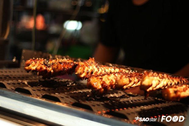 Mực nướng lốc xoáy: Nếu đã quen với khoai tây lốc xoáy, bạn đừng bỏ qua món mực lốc xoáy tại chợ đêm Shilint. Mực được xắt thành miếng, ướp gia vị, xỏ que và nướng than. Món ăn này có giá 60 Đài tệ (42.000 đồng).