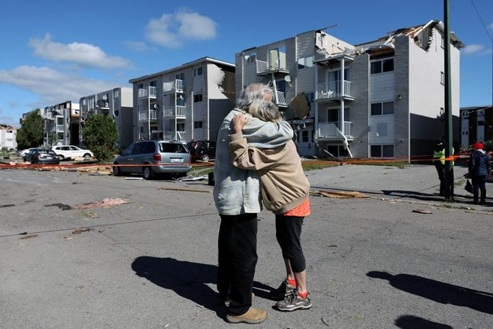 Hai người già cả ôm nhau sau khi nhà cửa của họ bị vòi rồng tàn phá. Cuộc sống của họ giờ đã bị xáo trộn lớn.