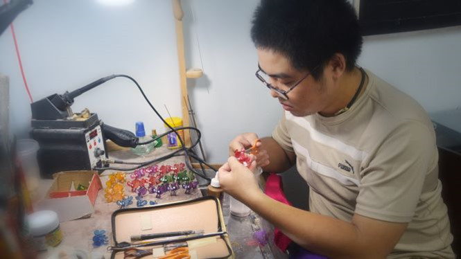 Kim Long tỉ mẩn trang trí cho lồng đèn. Ảnh: YI NGUYEN.