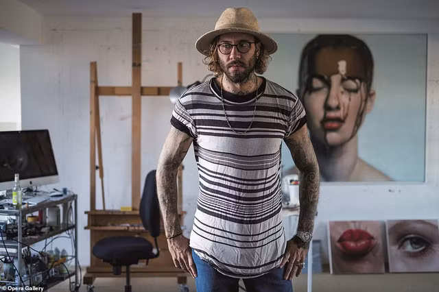 Họa sĩ Mike Dargas đứng bên những bức tranh của mình.