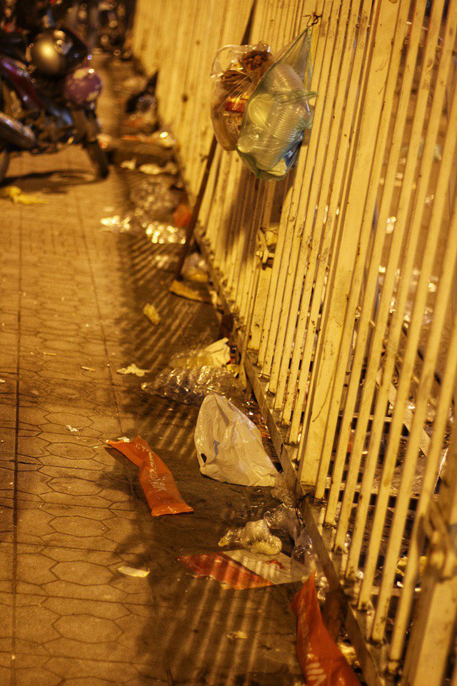 Rác mắc đầy trong khe dãy hàng rào chắn trước cổng sân vận động