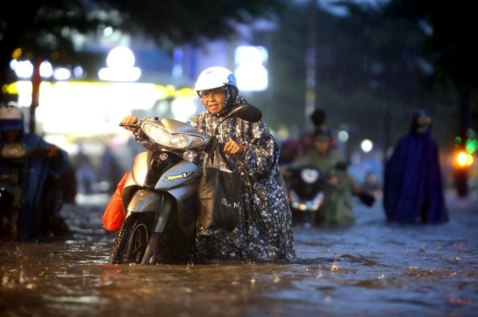 Đường Nguyễn Hữu Cảnh ngập sâu khiến nhiều xe máy bị tắt máy, người dân phải dắt bộ. ẢNH: NGỌC DƯƠNG.