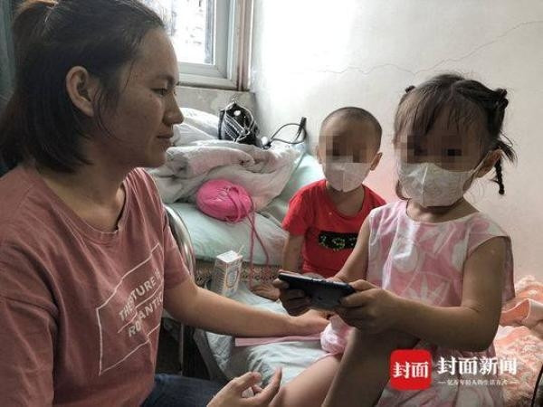 Người cha ôm theo bé gái cùng tấm bảng xin sự giúp đỡ đứng giữa phố. Người cha ôm theo bé gái cùng tấm bảng xin sự giúp đỡ đứng giữa phố.