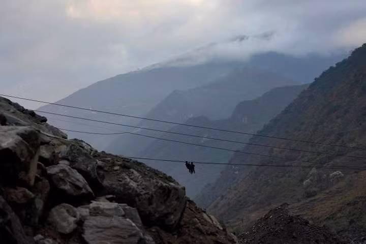 Dân làng Lazimi lơ lửng trên cáp sắt khi vượt sông Nộ. Họ sang sông còn để đi lễ tôn giáo. Cây cầu gần nhất bắc qua sông Nộ cũng cách chỗ này tới hơn 19km.