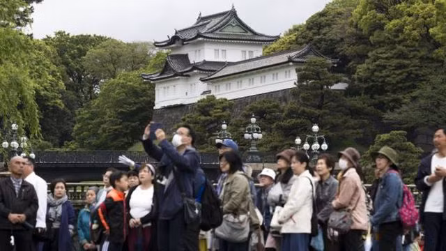 Người dân đứng trước cung điện Hoàng gia ở Tokyo trước thềm lễ thoái vị (Ảnh: Getty)