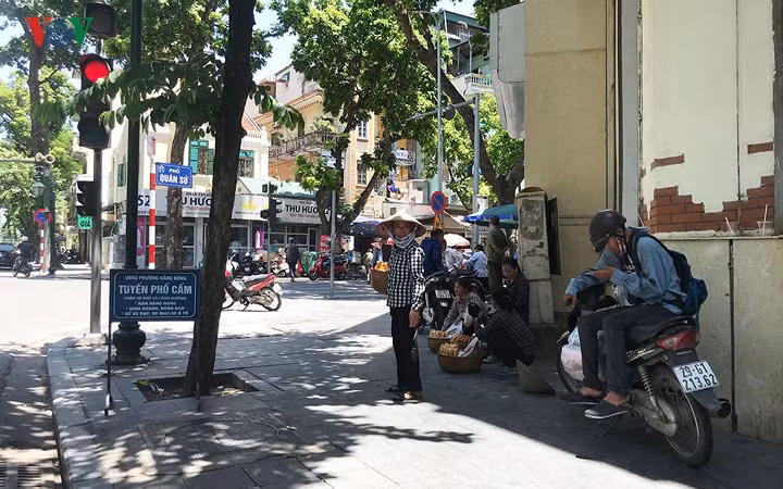 Vỉa hè tuyến phố cấm bán hàng hàng rong trở thành nơi tụ họp của những người bán hàng.