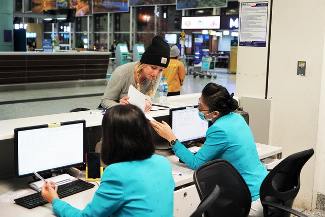 Nhân viên Vietnam Airlines đeo khẩu trang phòng dịch khi phục vụ hành khách đi máy bay