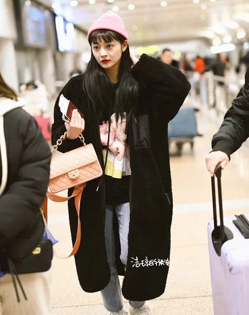 Thần tượng người Trung Quốc Kyulkyung (Pristin) diện item màu đen kết hợp với áo khoác hợp tông, đi kèm túi xách và mũ len hồng tăng độ nhí nhảnh.