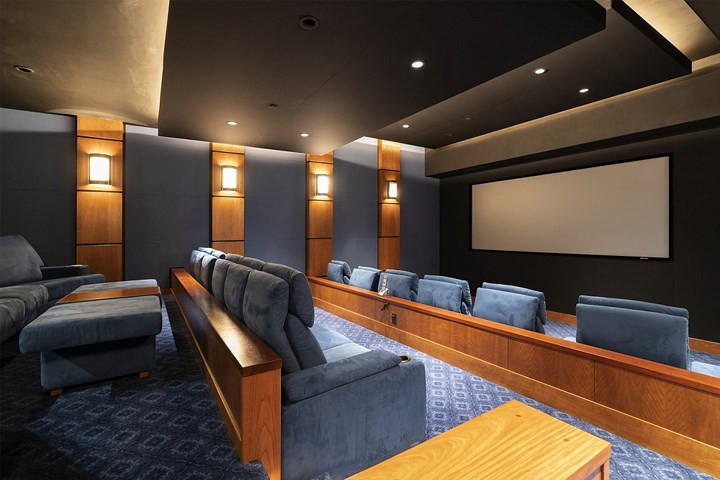 Phòng chiếu phim với các hàng ghế dài sang trọng và một màn hình.