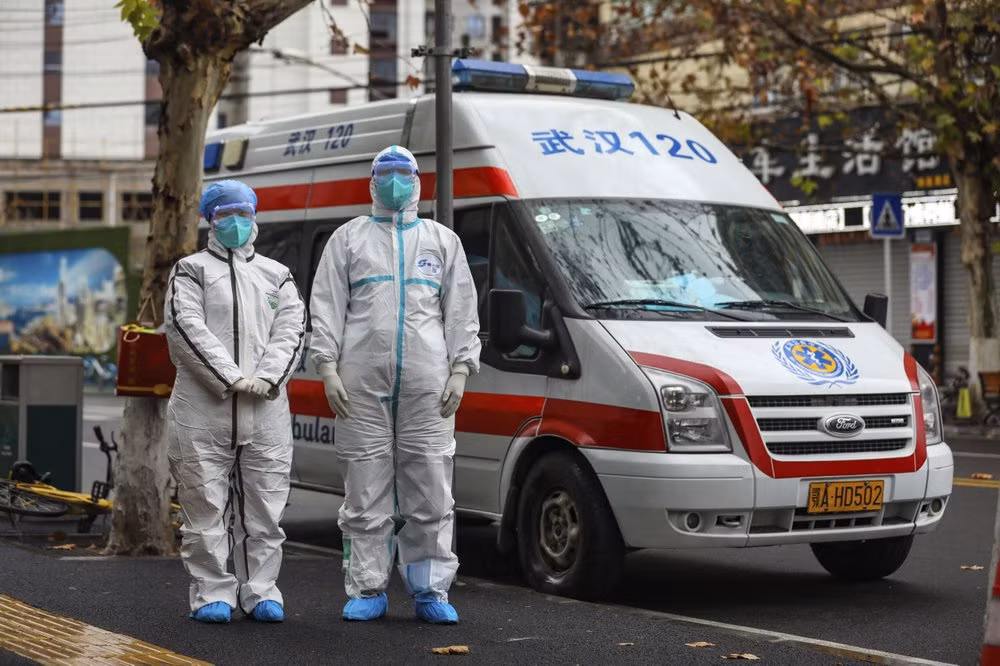 Nhân viên y tế đứng cạnh một xe cấp cứu tại Vũ Hán hôm 26/1. Ảnh: Xinhua/AP.