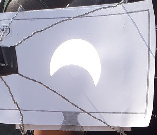 Ngắm nhật thực bằng phương pháp màn chiếu: Bóng của nhật thực được rọi từ kính thiên văn lên tấm bìa trắng. (Ảnh: Nhật Trinh)