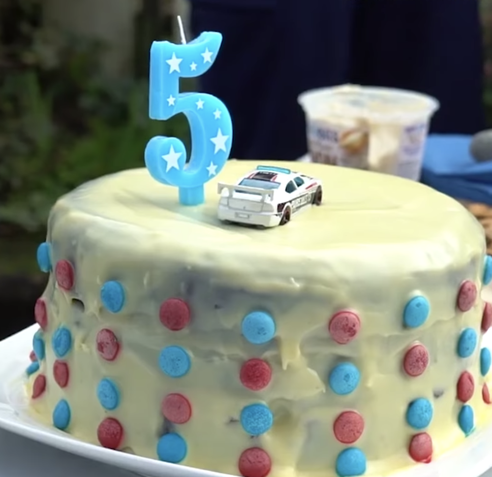 Cậu bé được tặng chiếc bánh kem với hình chiếc ô tô cảnh sát ở trên.