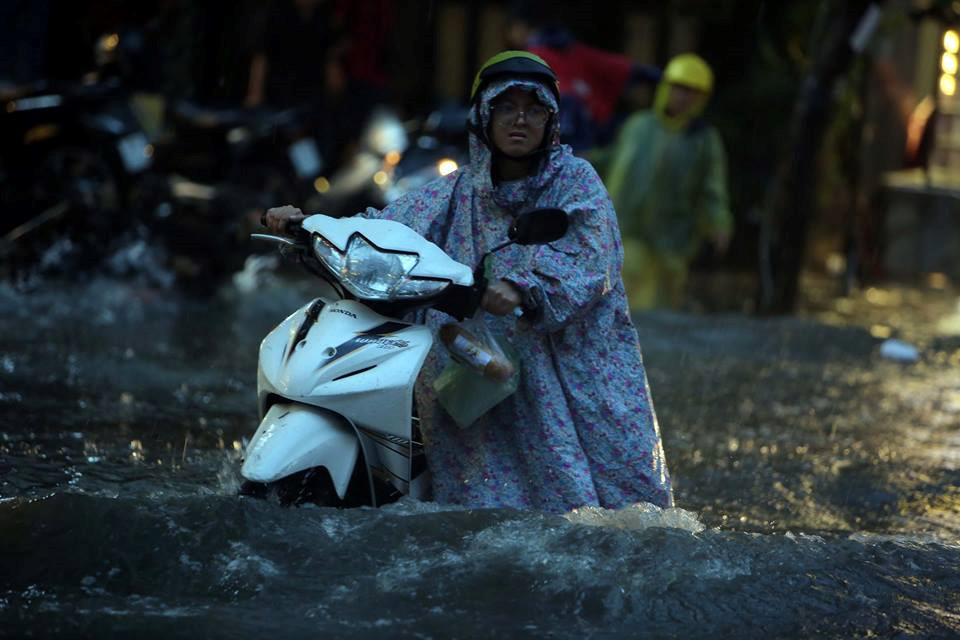 Chiều tối 25.11, cô gái trẻ cùng chiếc xe "bơi" giữa những con đường Nguyễn Hữu Cảnh (Q.Bình Thạnh) ngập nước. Trên xe là ổ bánh mì, có lẽ là bữa tối của cô gái ẢNH: NGỌC DƯƠNG