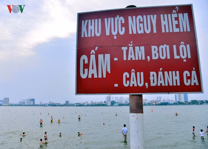 Thời tiết nắng nóng, cứ mỗi buổi chiều, hàng trăm người lại kéo nhau ra Hồ Tây tắm và bơi lội mặc dù đã có biển cảnh báo nguy hiểm.