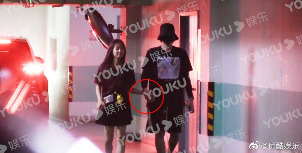 Kris và cô gái bí ẩn bị bắt gặp đang nắm tay nhau trong một bãi đỗ xe.