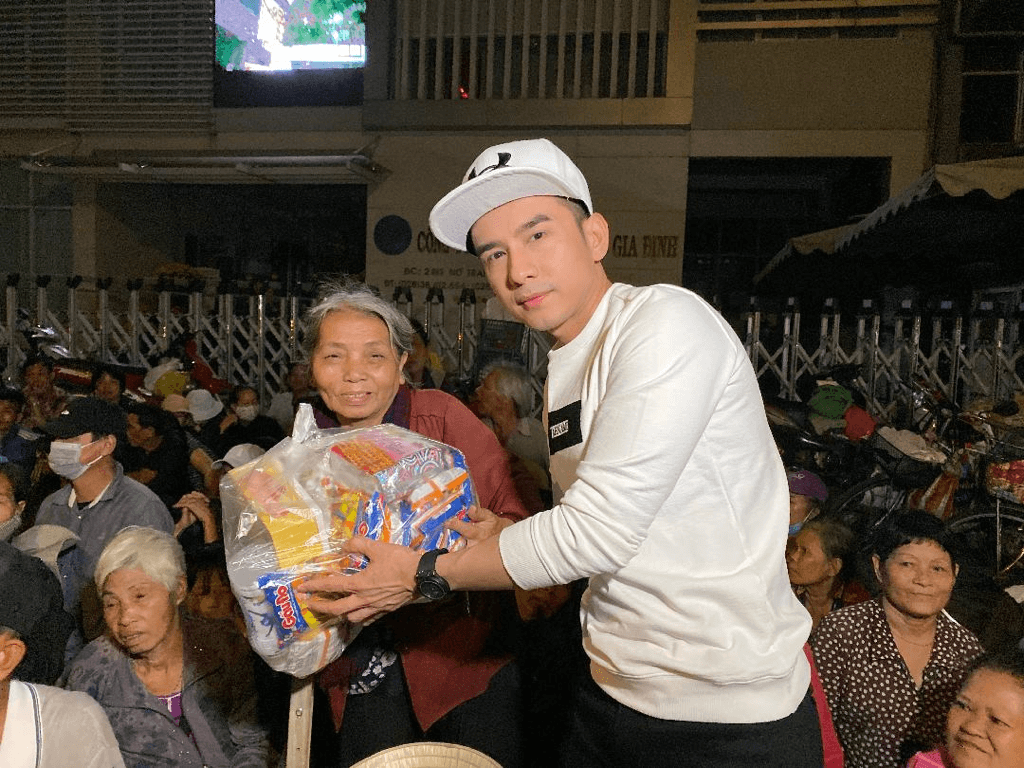 Đan Trường ân cần trao tận tay những món quà nhỏ và gửi lời chúc mừng năm mới đến mọi người.