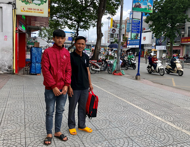 Em Lê Anh Tuấn và cha. Ảnh: MỸ QUYÊN.