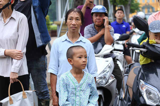 Người già, con trẻ trang nghiêm khi đoàn xe chở linh cữu đi qua.