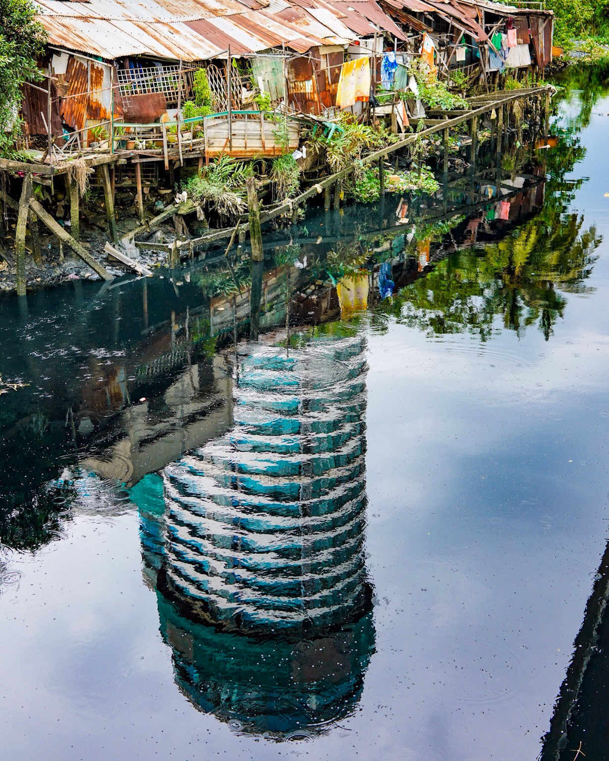 Những ngôi nhà mái tôn cũ kĩ nằm co ro ven sông.