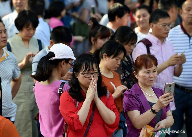 Con thi, cha mẹ ở bên ngoài cầu nguyện.