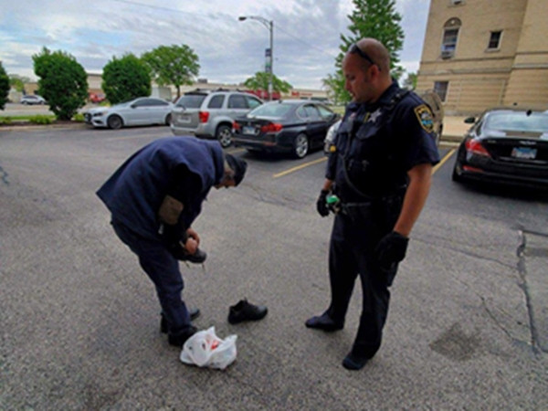 Ông cụ vô gia cư đang đi đôi giày của chú Brian vào.