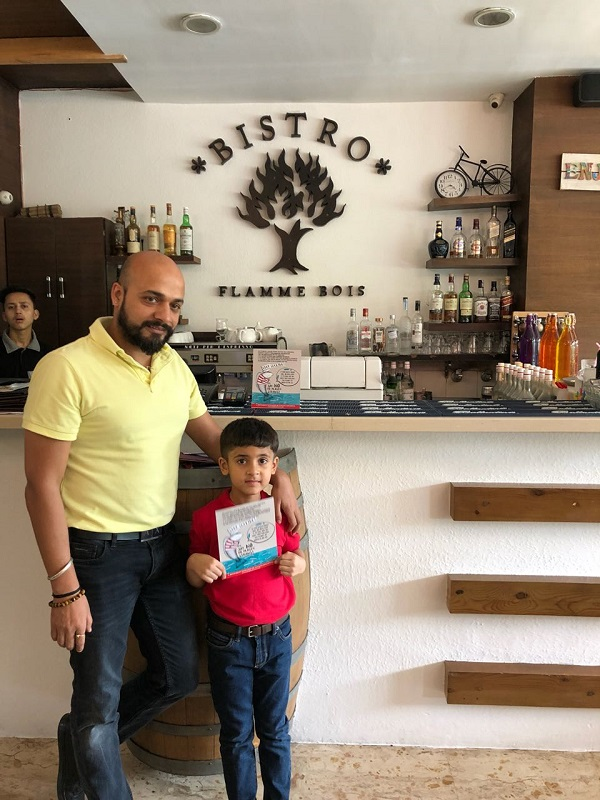 Cậu bé 7 tuổi cùng người chủ nhà hàng Flamme Bois. Nhà hàng này đã ngưng phục vụ ống hút cho khách hàng sau sự can thiệp của Aayaan.