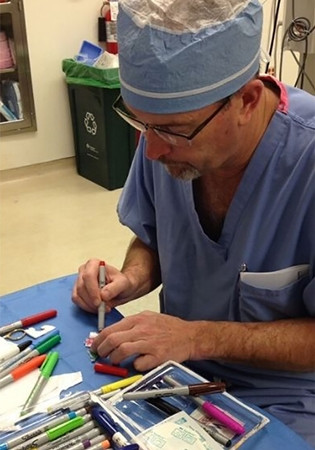 Bác sĩ Parry đang vẽ hình lên băng vết thương.