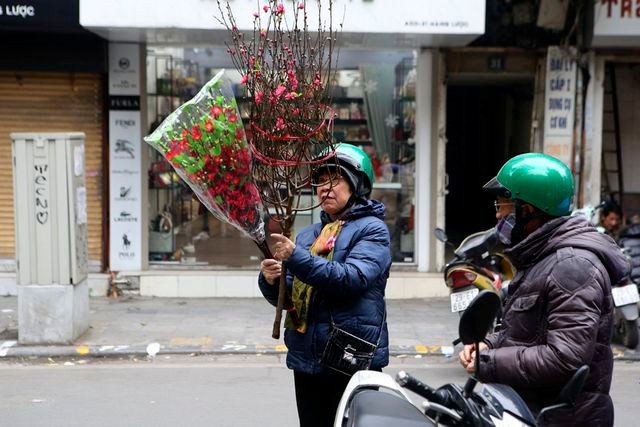 Những người già mua sắm đào Tết tại chợ hoa truyền thống.