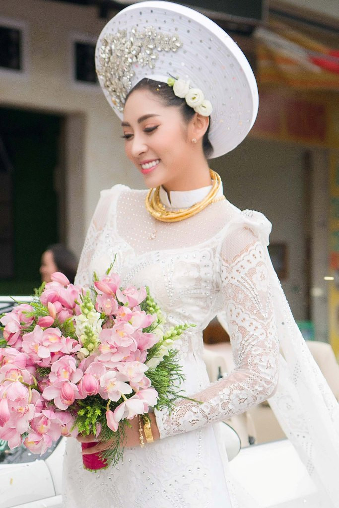 Hoa hậu Đại dương Đặng Thu Thảo xuất hiện nền nã trong bộ áo dài cưới khăn đóng truyền thống trắng tinh khôi mang tên Hỷ Phụng, được đính hai tà áo dài cánh tiên dài 3 mét.