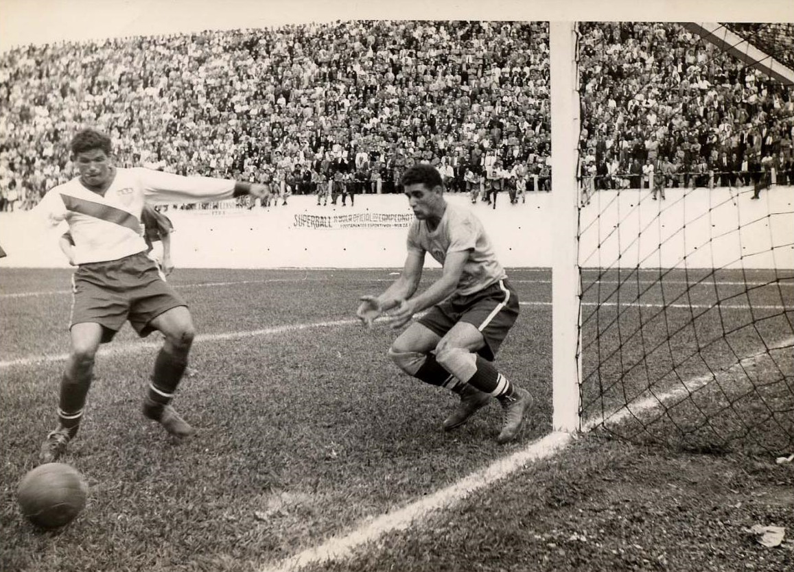 Harry Keough (áo trắng sọc xám) hỗ trợ đồng đội ngăn cản một pha tấn công của đội tuyển Anh. (Ảnh: St.Louis Sports Hall of Fame)