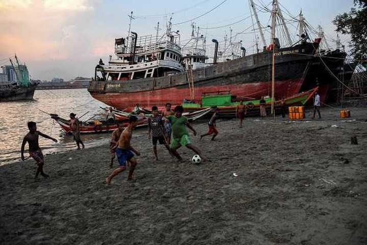 Sân bóng của các cậu bé Myanmar này chỉ đơn giản là một bãi cát bên bờ sông Yangon.