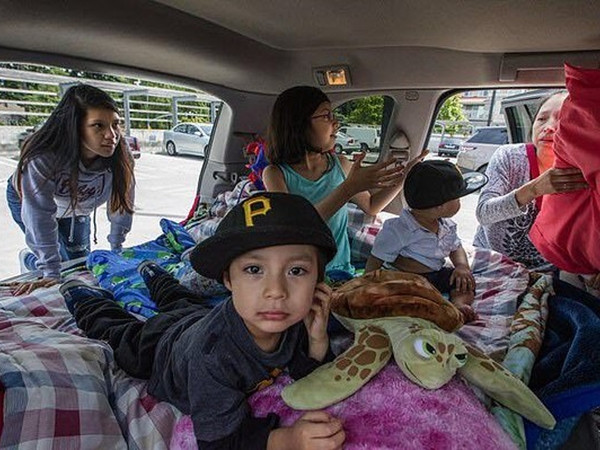 Một gia đình vô gia cư có chỗ ở tạm tại khu đỗ xe trưng bày.