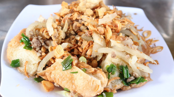 Một phần bánh mì hấp gồm có bánh mì hấp, sắn sợi, hành phi, mỡ hành, thịt bằm, đậu phộng, cuốn với rau sống kết hợp với nước mắm ngon. Ảnh: LÊ HỒNG HẠNH.