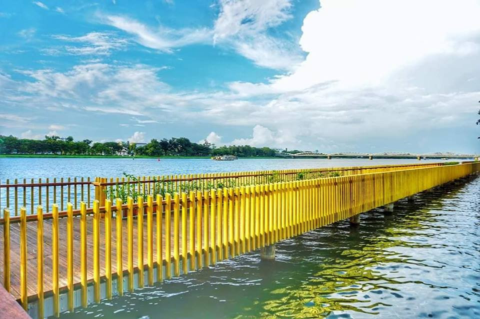 Cầu đi bộ này đi xuyên bên dưới cầu Phú Xuân đến đường Phạm Hồng Thái gần cầu Trường Tiền. Cầu dài hơn 380m, rộng hơn 4m và điểm đặc biệt là toàn bộ bề mặt sàn với diện tích hơn 2.440 m2 được lát hoàn toàn bằng gỗ lim Nam Phi đắt đỏ với 120 khối gỗ (khoảng 16.000 thanh, mỗi thanh rộng 15cm và dày 5cm). Hệ thống lan can 2 bên được làm bằng 4.100 thanh đồng nặng khoảng 7 tấn. Cầu được xây dựng từ tháng 2/2018 với tổng kinh phí 64 tỉ đồng, do Tổ chức Hợp tác quốc tế Hàn Quốc (KOICA) tài trợ không hoàn lại. Ảnh: Cầu gỗ lim Sông Hương