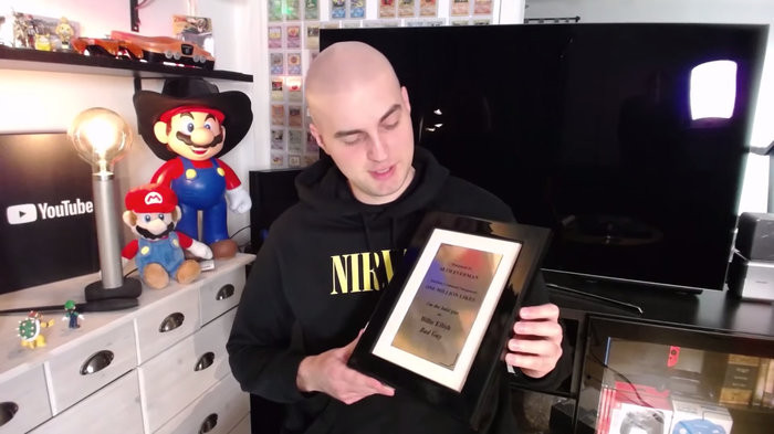 Seth Everman đang cầm trên tay Bảng Vàng nhờ sở hữu bình luận được 1 triệu lượt thích đầu tiên trên YouTube. (Ảnh: Seth Everman/YouTube)