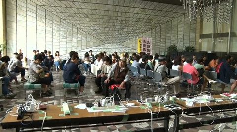 Người dân chờ sạc điện thoại. Ảnh: CHỤP TỪ CLIP.