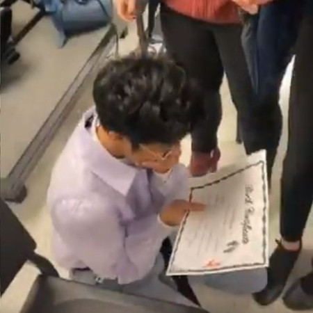 Bạn Andi đã ngồi thụp xuống và khóc khi đọc tờ “giấy khai sinh” mới do bạn bè làm.