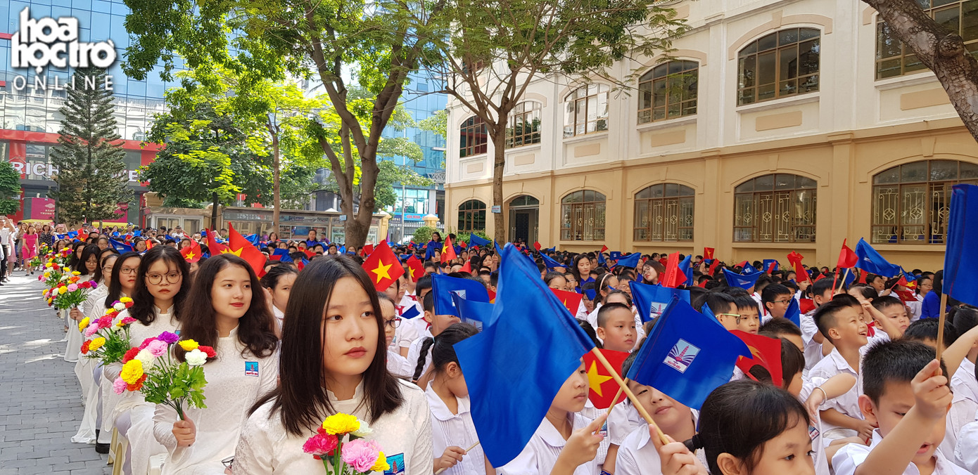 Cả sân trường rực rỡ với cờ và hoa.