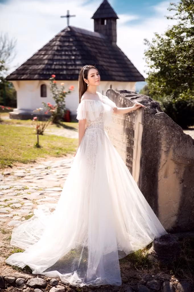 Nhấn nhá trên nền chất liệu voan bồng bềnh là những cánh hoa 3D uyển chuyển trên phần chân váy.