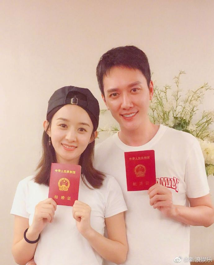 Cặp đôi cùng mặc áo trắng, khoe sổ chứng hôn đỏ thắm.