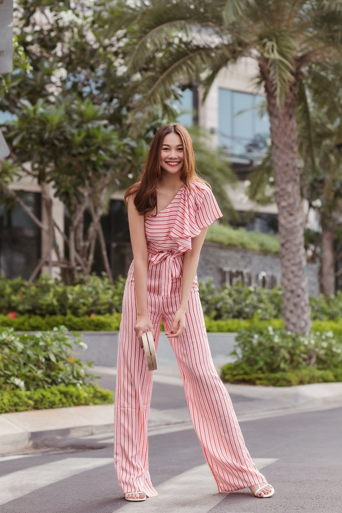 Một bộ jumpsuit cá tính hở một bên vai được siêu mẫu họ Phạm trưng dụng cho những ngày nắng nóng. Điểm nổi bật của jumpsuit chính là “ăn gian” chiều cao, chính vì vậy các cô gái chỉ cần khoác trên mình bộ cánh này sẽ “auto đẹp”.