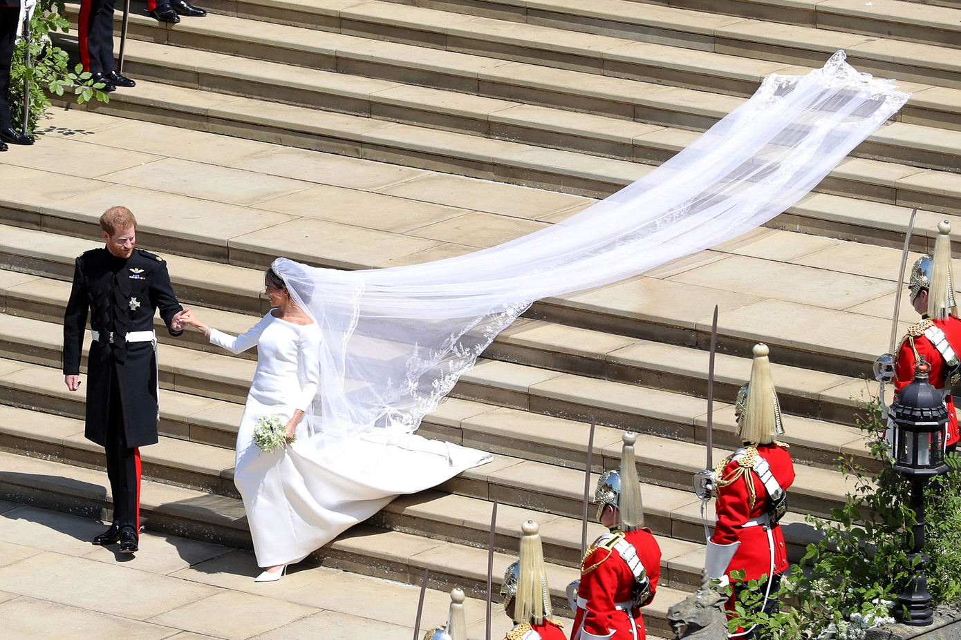 Harry nắm tay vợ bước ra ngoài nhà nguyện St George. ẢNh do Andrew Matthews ghi lại.
