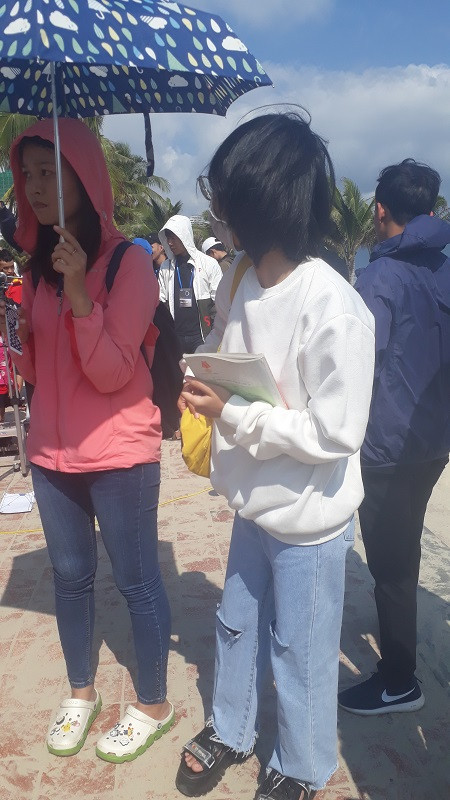 Vui ngắm nhật thực không quên ôn bài. Cô bạn áo trắng trong ảnh đã mang theo sách giáo khoa để tranh thủ ôn bài trong lúc chờ xem nhật thực. (Ảnh: Nhật Trinh)