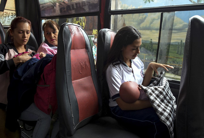 Các học sinh đưa em bé robot về nhà. Ảnh: AFP.