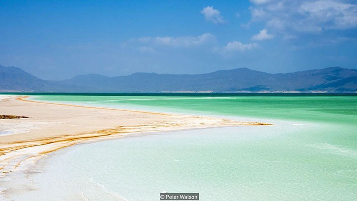 Lac Assal ở Djibouti (quốc gia Đông Phi) khiến nhiều người bị nhầm lẫn với bãi biển Caribbean. Phần bao quanh vùng nước rộng lớn ở đây không phải là cát, mà là muối. Trải nghiệm bộ chân trần trên cánh đồng muối hay bước xuống hồ nước không hề thoải mái. Ảnh Perter Watson